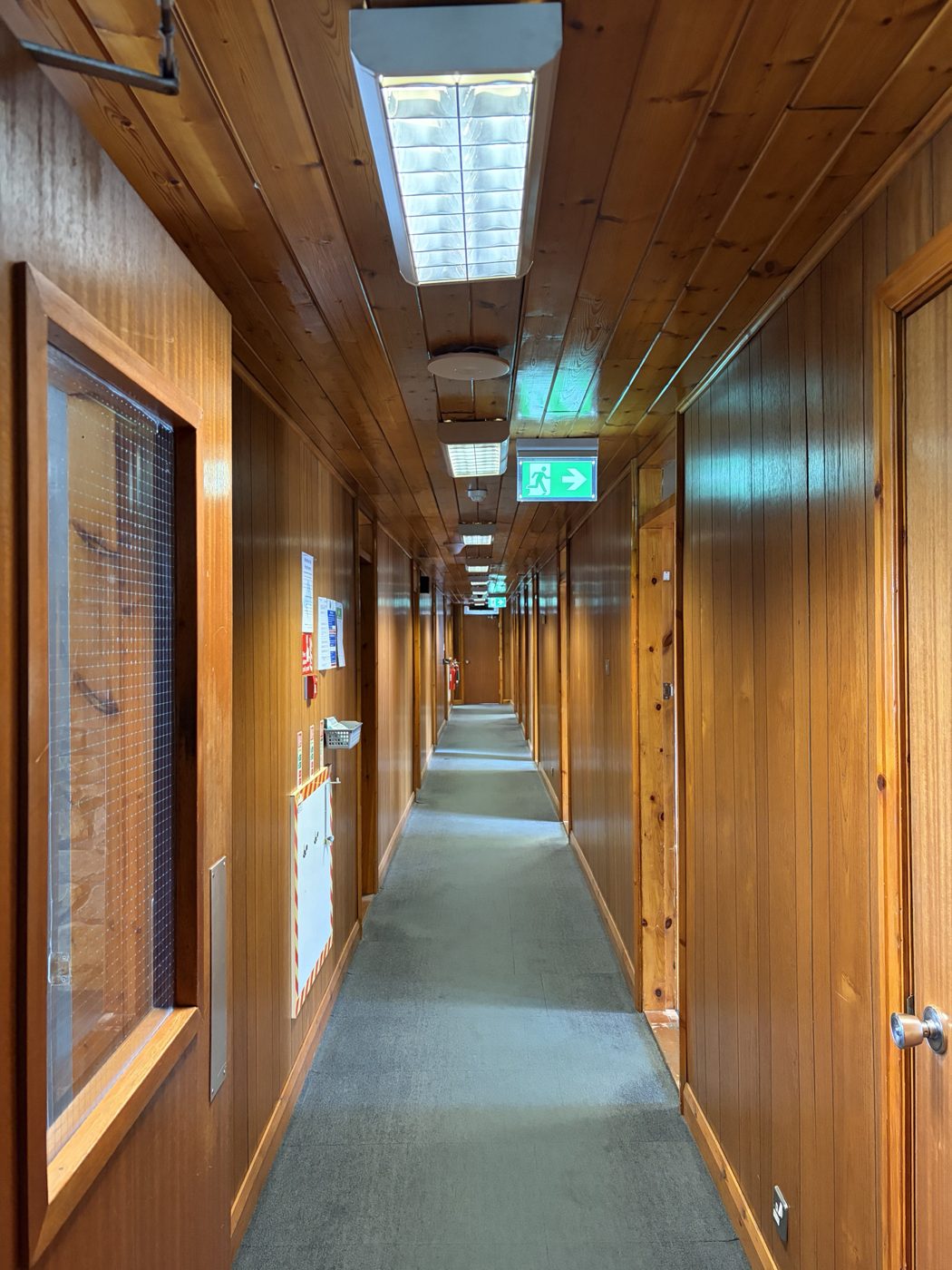 Office corridor before decoration, lined in dark timber panelling